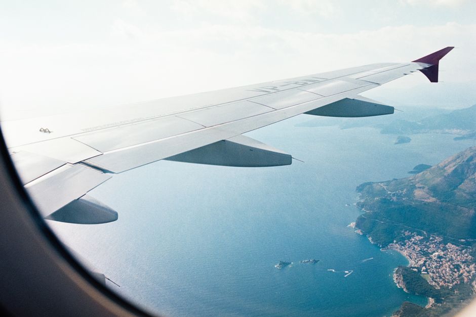 Aerial view from an airplane window of a scenic Mediterranean coastline.
